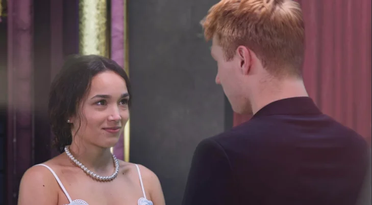 Juliet wearing a pearl necklace looks at Romeo in a scene from Romeo + Juliet