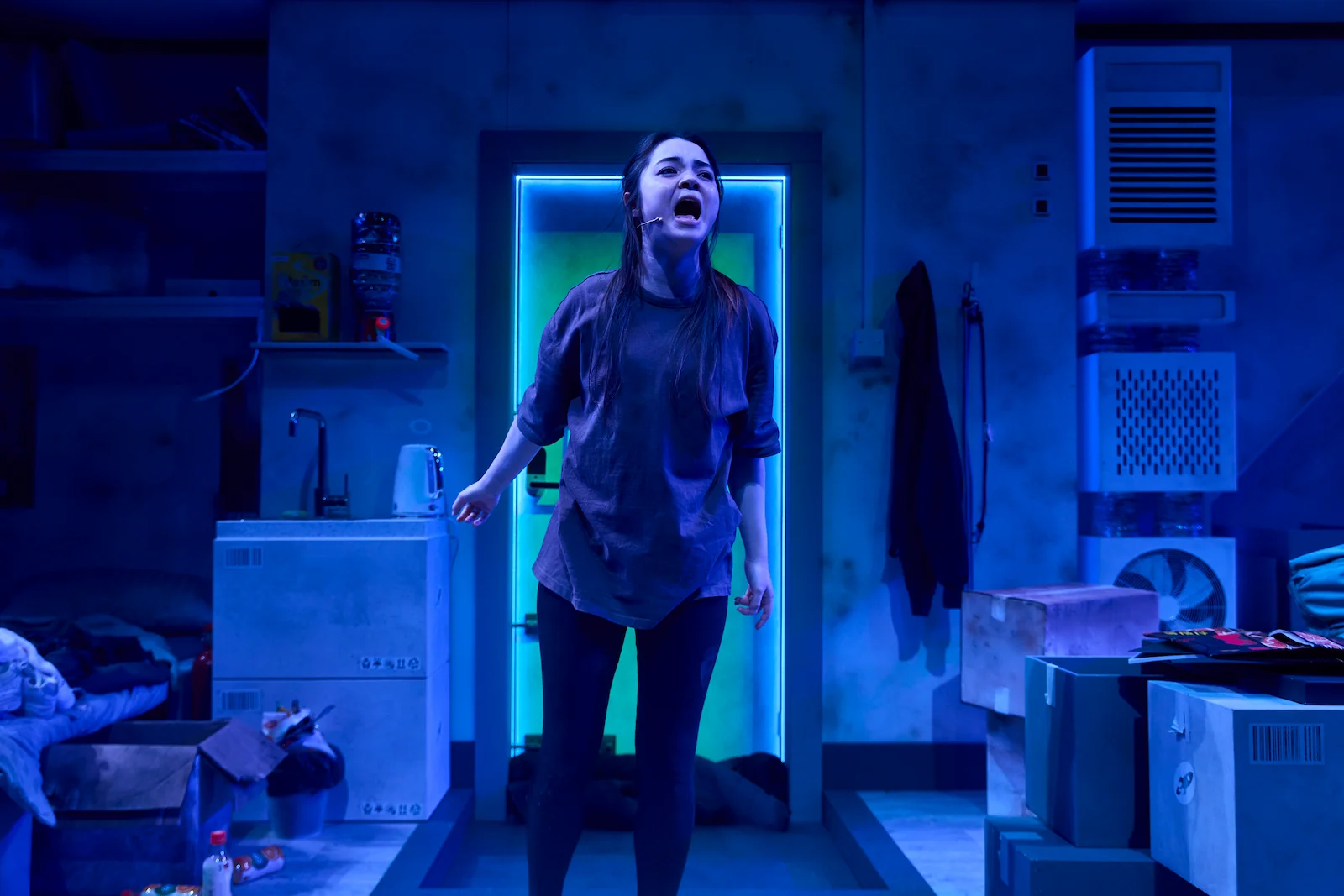 Nabi Brown performing in a blue-lit bunker in The Last Man